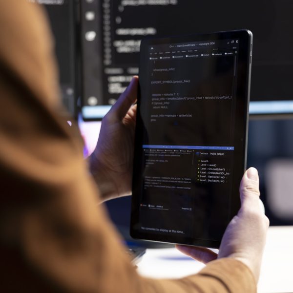 Teleworking programmer designing and developing software applications using tablet. IT administrator implementing and maintaining company systems using portable device, close up